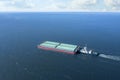 Tugboat pulling barge with cargo by water, aerial view