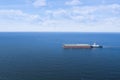 Tugboat pulling barge with cargo by water aerial view