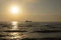 Tugboat pulling the tanker at sea in the sunset.