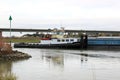 Tugboat pulls rudderless freighter at dutch river