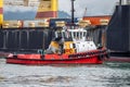 Tugboat push large cargo ship that has arrived at port dock. Freight sea transportation concept