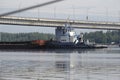 Tugboat pushes sand debris along the river