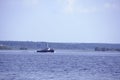 Tugboat pushes sand debris along the river