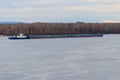 Tugboat pushing a heavy long barge on river Dnieper