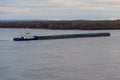 Tugboat pushing heavy long barge on the river Dnieper