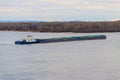 Tugboat pushing heavy long barge on the river Dnieper