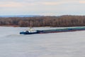 Tugboat pushing heavy long barge on the river Dnieper