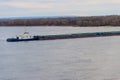 Tugboat pushing a heavy long barge on river Dnieper