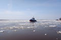 a tugboat sails along a large full-flowing spring river during the ice drift. sunny day, Royalty Free Stock Photo