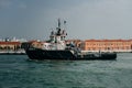 Tugboat sails off the coast of Venice