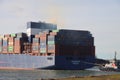 Tugship brings APL Merlion container ship inside the port of Rotterdam at the Maasvlakte Harbor Royalty Free Stock Photo