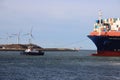 Tugship brings APL Merlion container ship inside the port of Rotterdam at the Maasvlakte Harbor Royalty Free Stock Photo