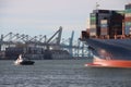 Tugship brings APL Merlion container ship inside the port of Rotterdam at the Maasvlakte Harbor Royalty Free Stock Photo