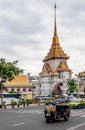 Tuk tuk and taxi traffic in the streets of central Bangkok, Thailand, with Wat Traimit, the Golden Buddha