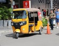 Tuk Tuk or Taxi tricycle in yellow color on the road, Lifestyle of traffic in Phnom Penh. It is a three-wheeled motorized vehicle