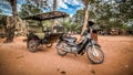 A tuk tuk parked outside Ta Prohm temple at Angkor Archaeological Park of Siem Reap in Ca