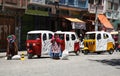 Tuk Tuk taxi cars and Bolivian women in a street, Coroico