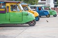 Tuk tuks lined up in a side ally