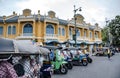 Tuk-tuks are parked to pick up tourists around the centuries-old building called Wang Tha Chang in the past in Bangkok, Thailand