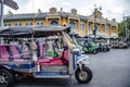 Tuk-tuks are parked to pick up tourists around the centuries-old building called Wang Tha Chang in the past in Bangkok, Thailand