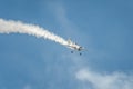 Airplane performing at airshow and leaves behind a smokes in the sky