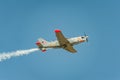 Airplane performing at airshow and leaves behind a smokes in the sky