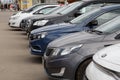 Row of cars on summer day parking - close-up view on noses from side Royalty Free Stock Photo