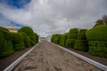 TULCAN, ECUADOR - JULY 3, 2016: grey cobble path with some topiary sculptures on the sides