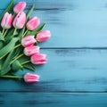 Tulip border with copy space. Bouquet of pink tulips flowers on turquoise blue vintage wooden background. generative ai. Beautiful Royalty Free Stock Photo
