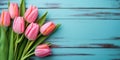 Tulip border with copy space. Bouquet of pink tulips flowers on turquoise blue vintage wooden background. generative ai. Beautiful Royalty Free Stock Photo