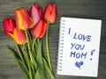 Tulip bouquet and notepad with words `I love you mom`