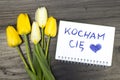 Tulip bouquet and notepad with words `kocham ciÃâ¢` Royalty Free Stock Photo