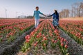 Tulip flower field during sunset dusk in the Netherlands Noordoostpolder Europe, happy young couple men and woman with Royalty Free Stock Photo