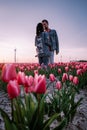 Tulip flower field during sunset dusk in the Netherlands Noordoostpolder Europe, happy young couple men and woman with Royalty Free Stock Photo