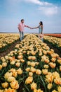 Tulip flower field during sunset dusk in the Netherlands Noordoostpolder Europe, happy young couple men and woman with Royalty Free Stock Photo