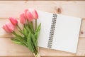 Tulip flower with white blank note book page background on white wood backdrop for motherÃ¢â¬â¢s day holiday card Royalty Free Stock Photo