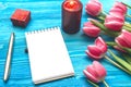 Tulip flowers and blank note pad paper page on wooden background with copy space. Woman day concept. Romantic background. Royalty Free Stock Photo