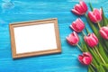 Tulip flowers and empty photo frame on wooden background with copy space. Woman day concept. Romantic background. Royalty Free Stock Photo