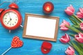 Tulip flowers and empty photo frame on wooden background with copy space. Woman day concept. Romantic background. Royalty Free Stock Photo