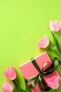 Tulip flowers and gift box on vertical green background. Happy Mothers Day, Birthday concept Royalty Free Stock Photo