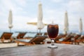 Tulip glass with cola on table. Beach umbrellas on the background Royalty Free Stock Photo