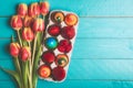 Tulips bouquet and easter eggs on blue table Royalty Free Stock Photo