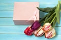 Tulips with box on a wooden background Royalty Free Stock Photo