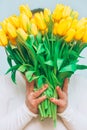 Tulips. Bright bouquet of yellow tulips in female hands. Spring flowers. Flowers tulips for mother, wife, girlfriend etc, conceptu