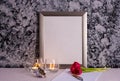 Tulips, burning candles and photo frame and writing materials on gray background