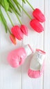 Tulips flowers and boxing gloves on wooden background, femenism concept