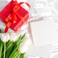 Tulips flowers, red gift box and empty card for text. Mock-up. Concept of womans day, mothers day Royalty Free Stock Photo