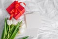 Tulips flowers, red gift box and empty card for text. Mock-up. Concept of womans day, mothers day Royalty Free Stock Photo