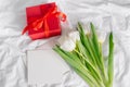 Tulips flowers, red gift box and empty card for text. Mock-up. Concept of womans day, mothers day Royalty Free Stock Photo