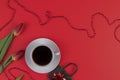 Tulips, gift and cup of coffee on red background. Flat lay, top view. Royalty Free Stock Photo